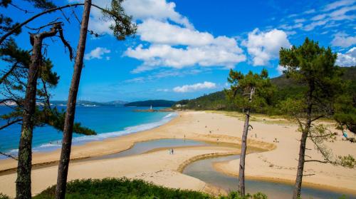 a beach with a group of people on it at Casa Muxia in Muxia