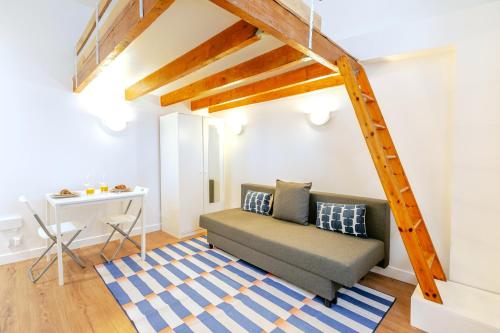 un salon avec un canapé et une table dans l'établissement Studio cool avec mezzanine 17ème arrondissement, à Paris