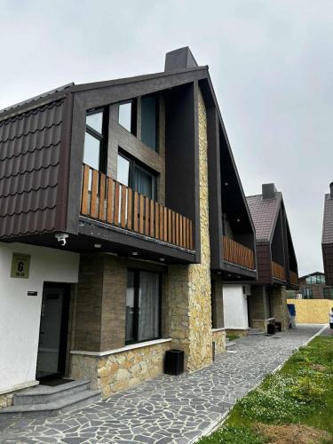 a building with a balcony on the side of it at Bakuriani Cottages in Bakuriani