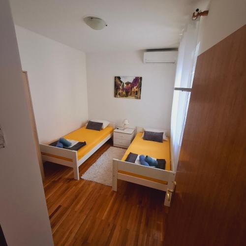 a small room with two beds and a door at Apartment ARIELA in Tisno