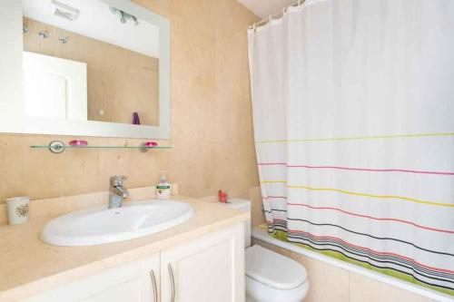 a bathroom with a sink and a shower curtain at Apartment in Palm Mar - Insel Teneriffa 53099 in Palm-mar