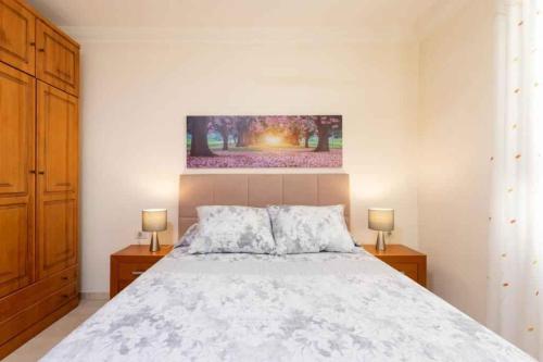 a bedroom with a white bed with two night stands at Apartment in Palm Mar - Insel Teneriffa 53099 in Palm-mar