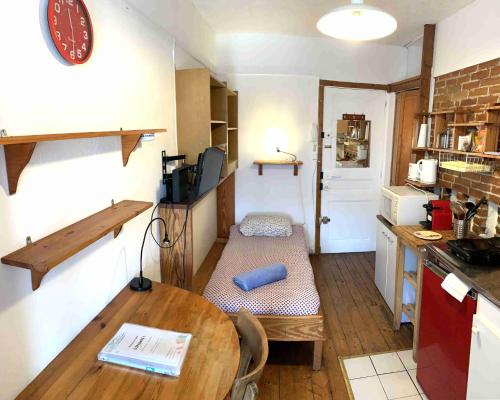 une petite pièce avec une table et une cuisine avec un comptoir dans l'établissement Studio Eléphants 1, à Chambéry