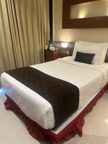 AmarnāthにあるThe Comfort Ambernathのベッドルーム1室(大型ベッド1台、黒い毛布付)
