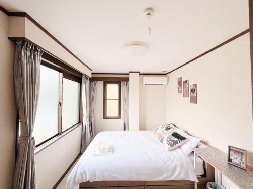 a bedroom with a bed and a window at 花乃郷 川口 駅徒歩5分 上野 秋葉原 東京直通 池袋 新宿20分圏内 WiFi付き 洋室 温泉施設近く in Kawaguchi