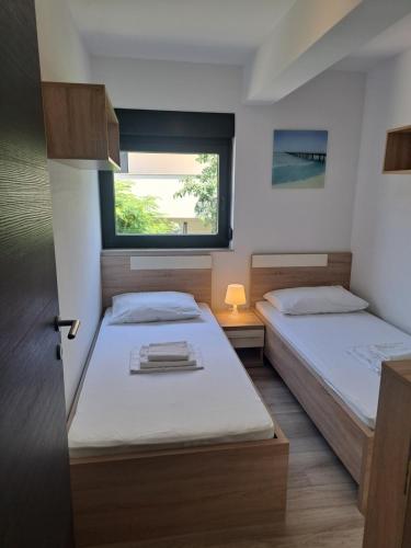 twee bedden in een kleine kamer met een raam bij Beach apartment in Mandre in Mandre