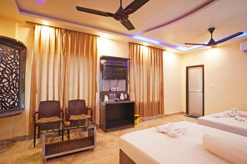 a hotel room with two beds and a television at Holiday Beach Resort !! Beach Distance 50 Mts !! in Mandarmoni