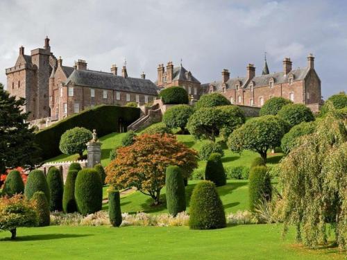a garden in front of a castle with trees and bushes at 1 Bed in Crieff 87497 in Crieff