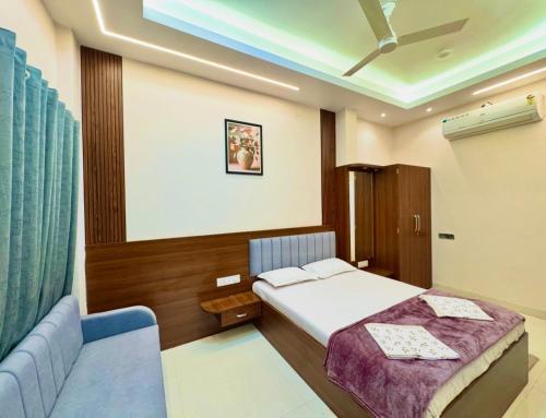 a bedroom with a bed and a blue couch at Surya Vilas Palace in Ujjain