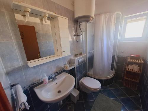 a bathroom with a white sink and a toilet at Apartment ARIELA in Tisno