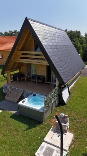 a large house with a hot tub in the yard at Planinska kuća za odmor Aneva in Sveti Rok