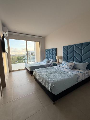 a bedroom with two beds and a large window at Serena del Mar, Morros IO in Cartagena de Indias