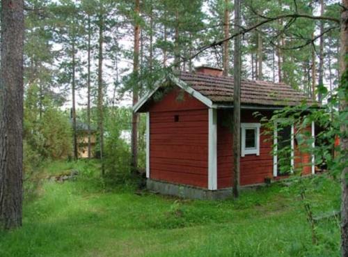 a small red house in the middle of a forest at Taivasalla glamping - luxury stay with a view to the lake in Tampere