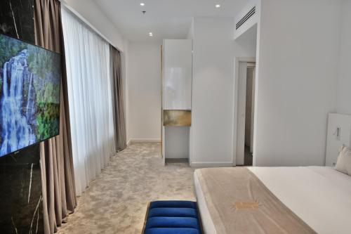a bedroom with a bed and a large screen at Habitat Hotel Tirana in Tirana