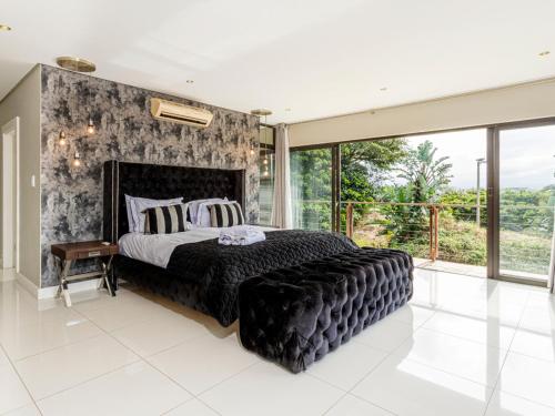a bedroom with a large bed and a large window at Corals 4, Zimbali Estate by Euphoric Leisure in Ballito