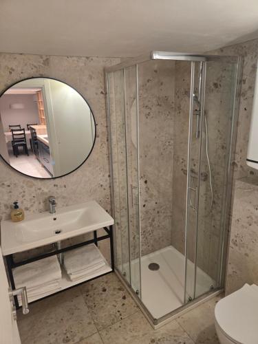 Un baño con ducha, lavabo y espejo. en Apartment Petra, en Mošćenička Draga