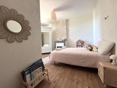 a bedroom with a bed and a mirror on the wall at Demeure dans la fôret in Belin-Beliet