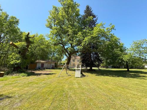 a playground in the middle of a field with trees at Demeure dans la fôret in Belin-Beliet