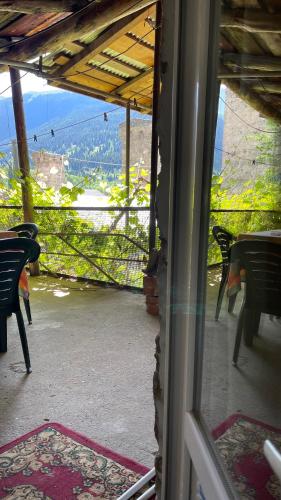 a view from a window of a patio with chairs and a view at Guesthouse Chela in Mestia