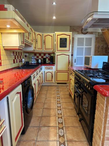 a kitchen with a stove and a washer and dryer at L'étape Giennoise in Gien