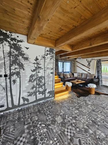 a living room with a mural of trees on the wall at Chata Ďumbier in Bystrá
