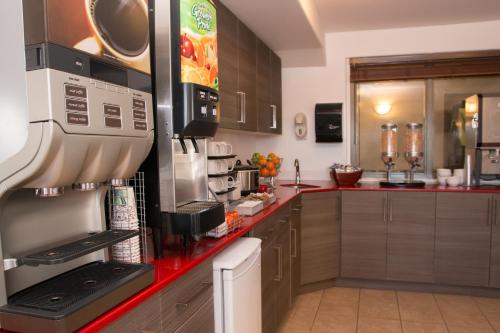a kitchen with a microwave oven and a refrigerator at Super 8 by Wyndham Truro NS in Truro