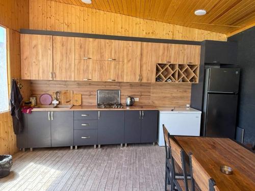 a kitchen with wooden cabinets and a black refrigerator at ARThouse Garni in Garni