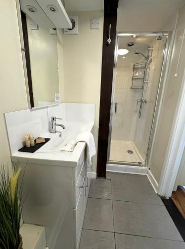 a white bathroom with a sink and a shower at Thatched Cottage Hotel in Brockenhurst