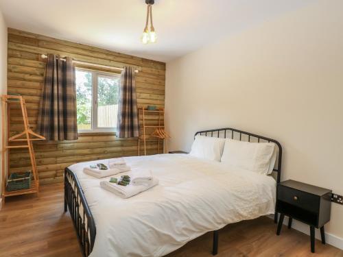 a bedroom with a bed with two towels on it at Barn Owl Lodge in Snettisham