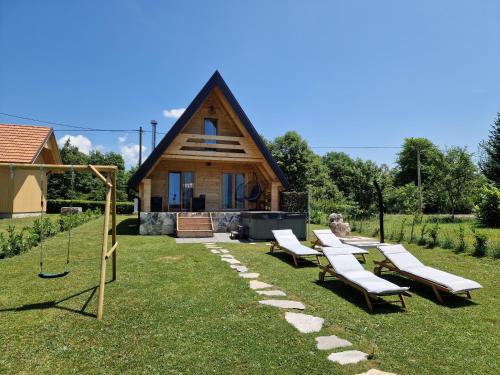 a group of lounge chairs in front of a house at Planinska kuća za odmor Aneva in Sveti Rok