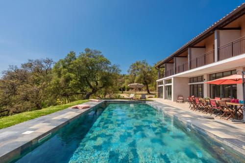 une piscine dans l'arrière-cour d'une maison dans l'établissement Grande Villa 750 m2 Le Mas des chênes, à Bormes-les-Mimosas