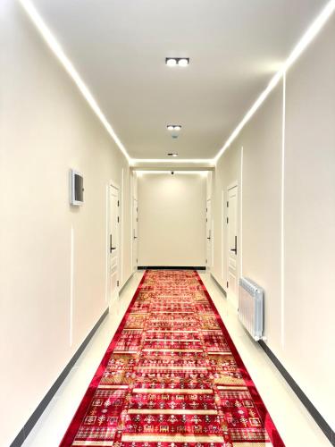 an empty corridor with a red carpet in a building at QUT Hotel in Almaty