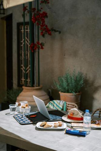 a table with a laptop and plates of food on it at Zacosta Villa Hotel in Rhodes Town