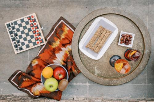 a table with a bowl of fruit and a plate of food at Zacosta Villa Hotel in Rhodes Town