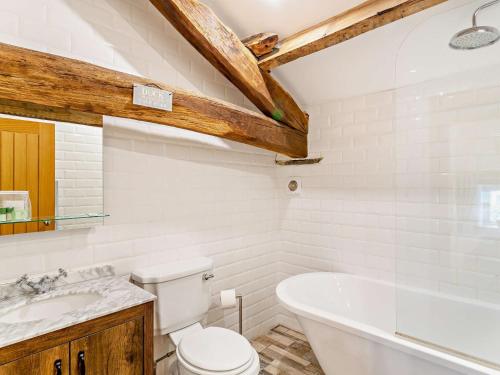 a bathroom with a tub and a toilet and a sink at 3 Bed in Settle 76650 in Stainforth