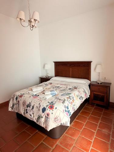 a bedroom with a bed and two nightstands and two lamps at Apartamentos Bodeguetas in Constantina
