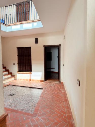 an empty room with a staircase and a brick floor at Apartamentos Bodeguetas in Constantina