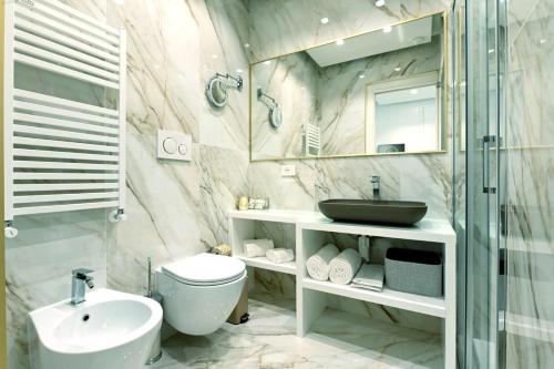 a bathroom with a sink and a toilet and a mirror at Golden House Cinecittà in La Romanina