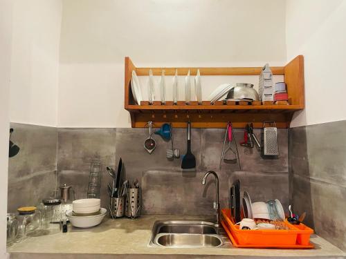 a kitchen with a sink and a shelf with utensils at Marisol Villa in Unawatuna