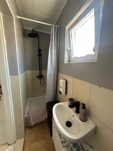 a small bathroom with a sink and a shower at Apartments Kovač in Vir