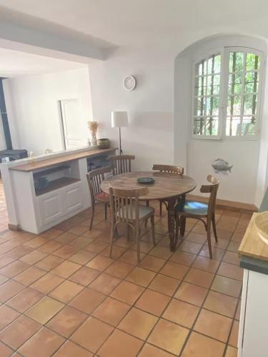 une salle à manger avec une table et des chaises dans une pièce dans l'établissement Rez-de-jardin villa provençale vue mer, à Marseille