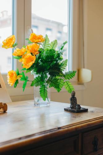 a vase filled with orange flowers on a table at Rent4Rest Lisbon Family & Friends apartment in Roma Avenue in Lisbon