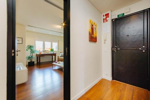 a hallway with a black door and a living room at Rent4Rest Lisbon Family & Friends apartment in Roma Avenue in Lisbon