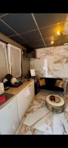 - une cuisine avec des comptoirs en marbre et un évier dans l'établissement Ô Saphir Spa - Maison N2, à Denain