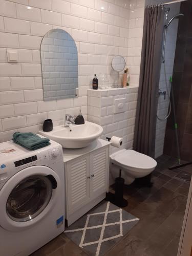 Un baño con lavadora y lavabo. en Kuninga Holiday Apartment, en Pärnu