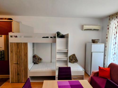a small room with a bunk bed with purple accents at TihON Studio in Byala