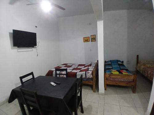 a room with two beds and a table and a tv at Avenida Colon in Santiago del Estero
