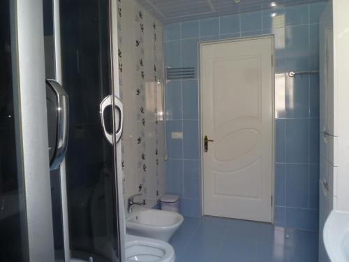 a blue bathroom with a toilet and a sink at Zekorei Guest House in Kutaisi