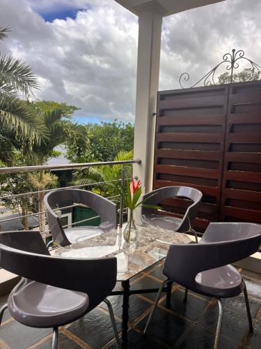 a patio with a table and chairs on a balcony at Joubarbe Residence in Moka