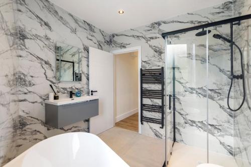 un baño con ducha y lavabo en Kew Garden Suite 2BR Sleeps 9 Near Central London, en Richmond upon Thames